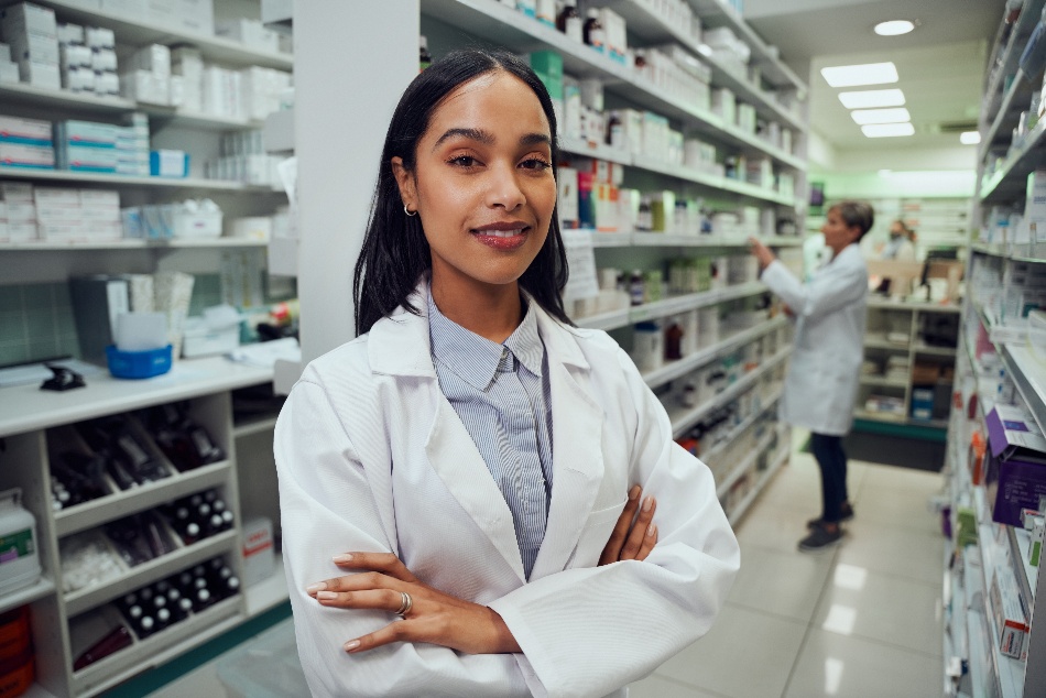 young-african-american-pharmacist-standing-between-aisle-in-a-whitecoat